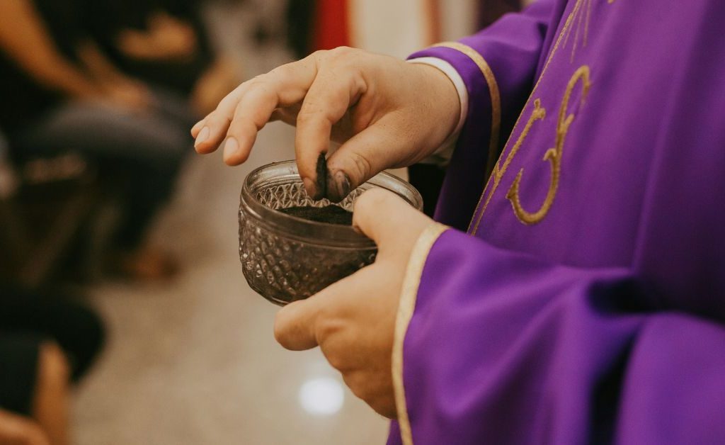Priest with ash on Ash Wednesday